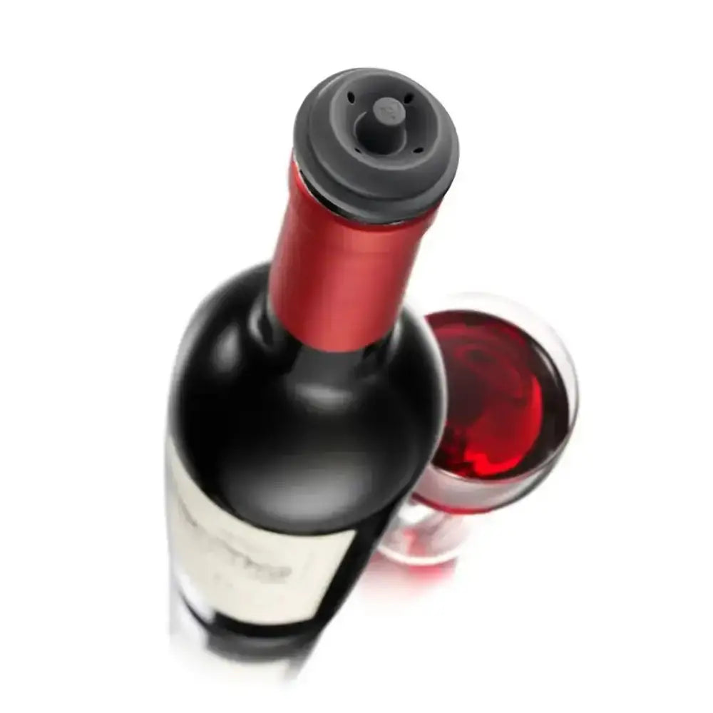 Red wine bottle with a black cap and a glass of red wine on a white background