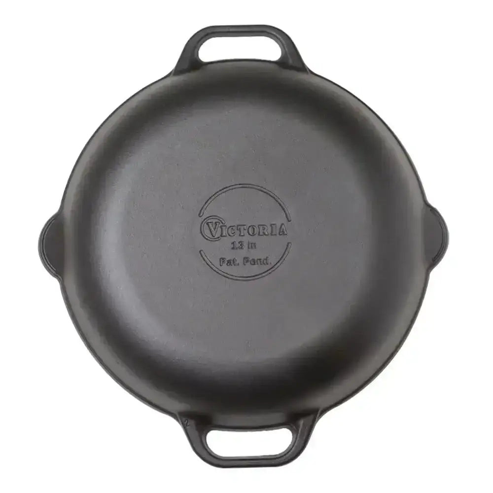 Black cast iron skillet with 'Victoria' branding on a white background