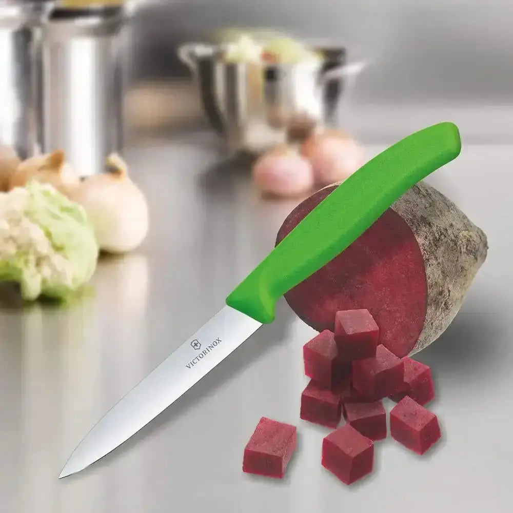 Green-handled knife with diced beetroot on a kitchen counter