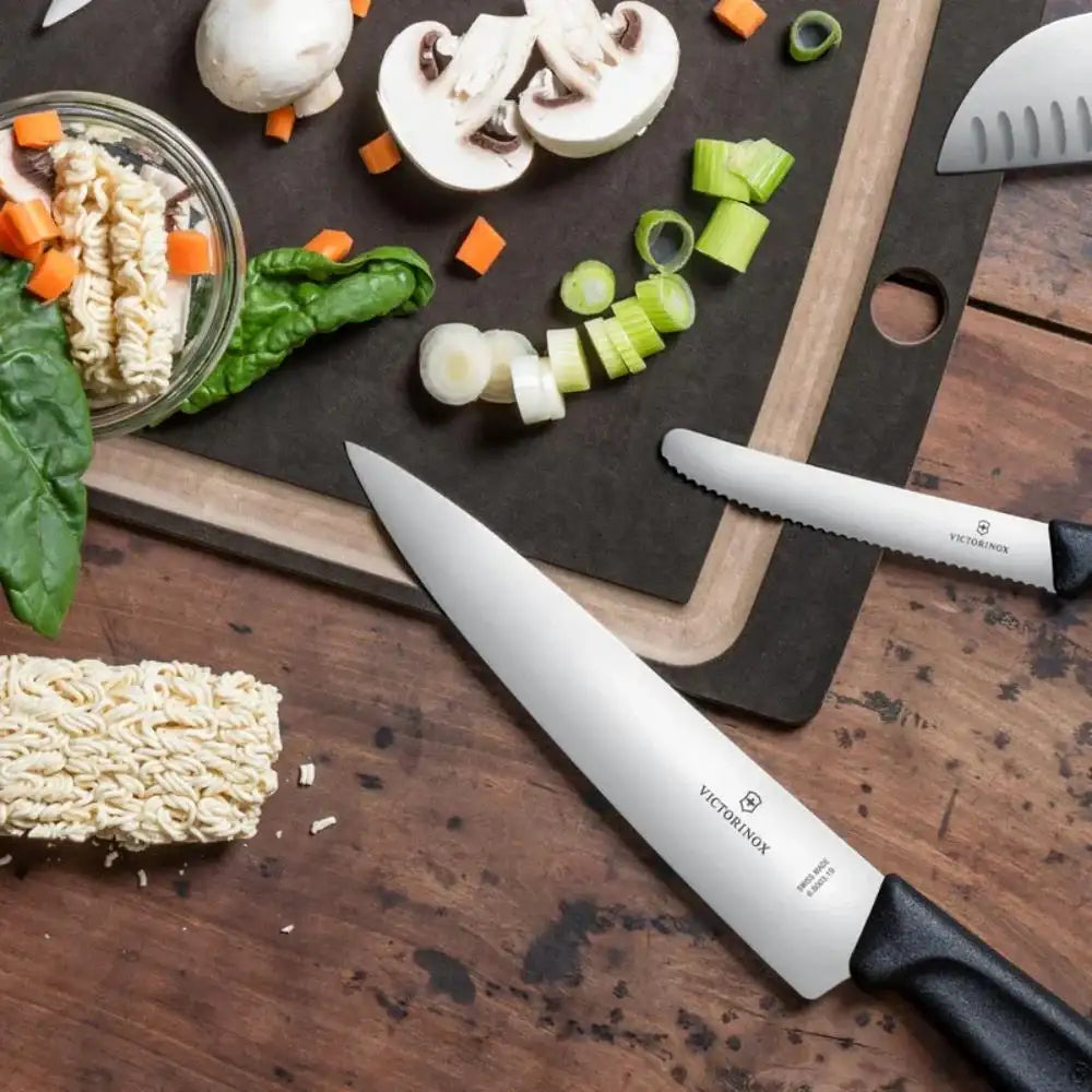 Victorinox knife on a wooden surface with vegetables and pasta
