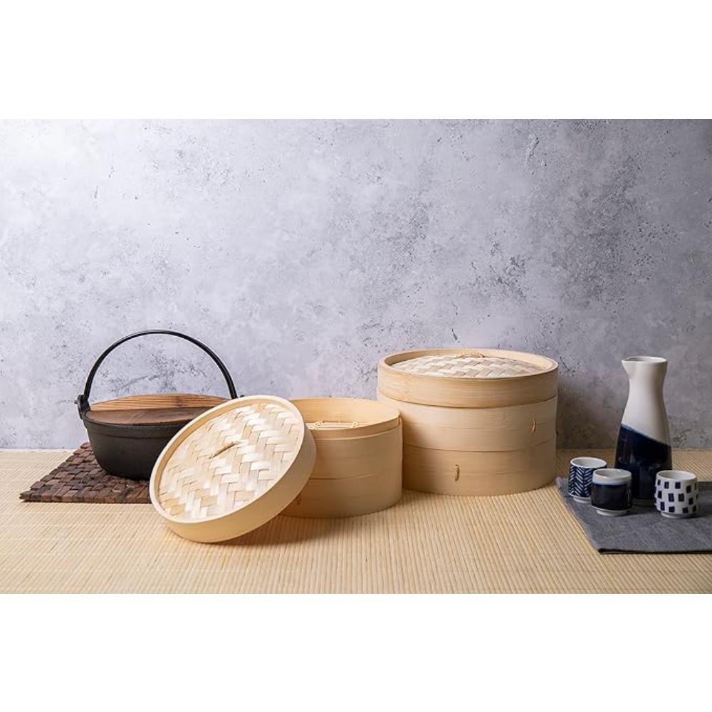 Set of bamboo steamers on a table with a gray wall background