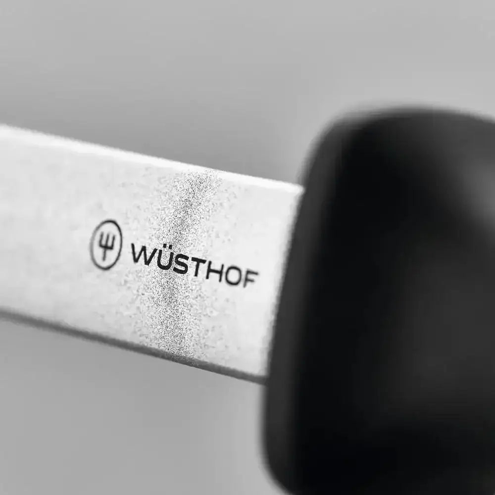 Wüsthof knife blade with logo on a gray background