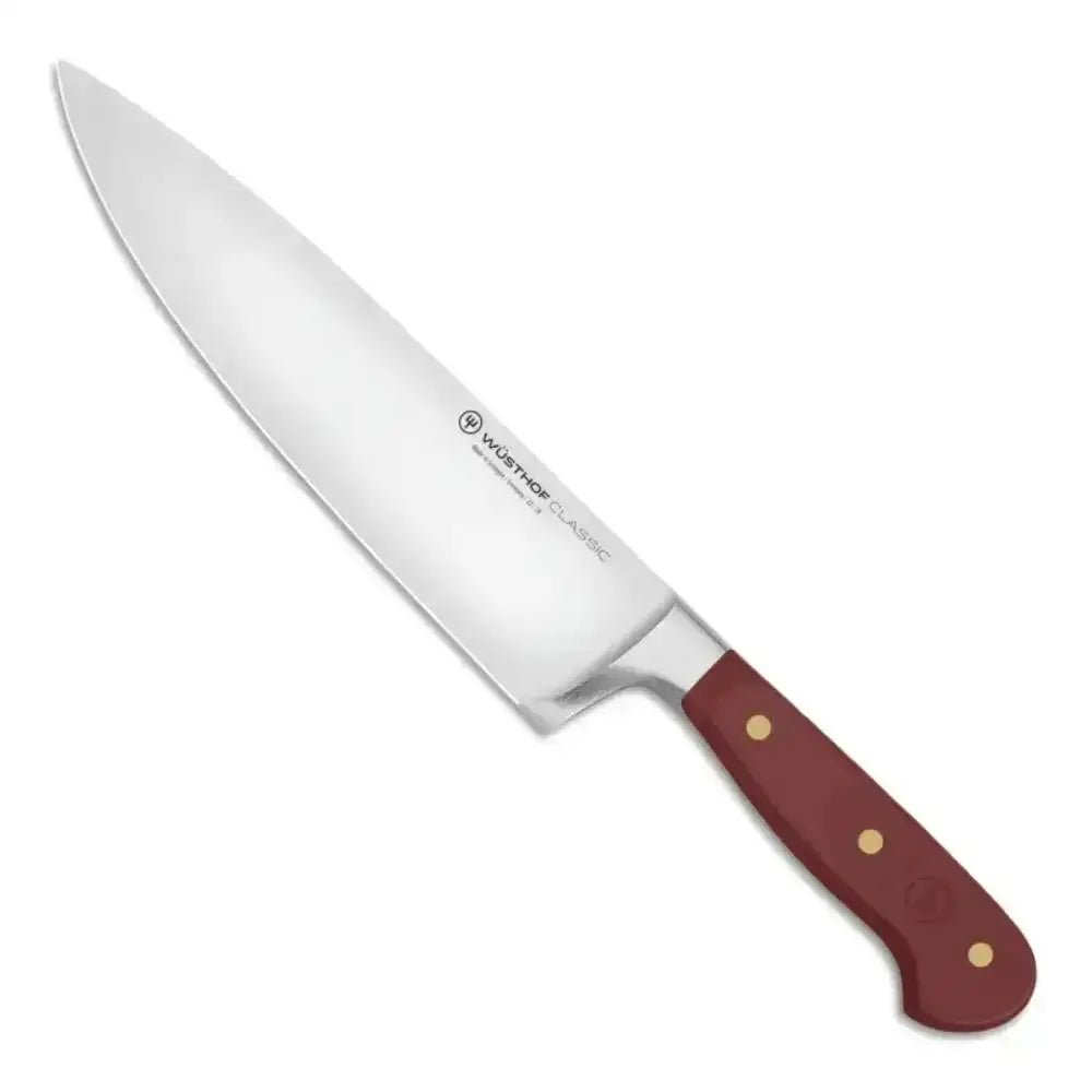 Chef's knife with a red handle on a white background