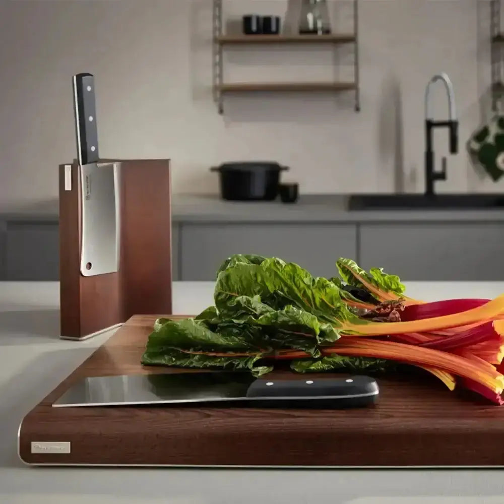 Wooden cutting board with vegetables and knife set on a kitchen counter