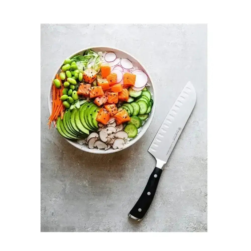 Assorted vegetables in a bowl with a knife on a gray surface