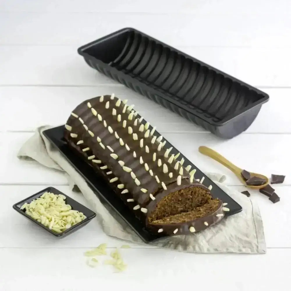 Chocolate mold with a loaf of bread inside on a white wooden surface