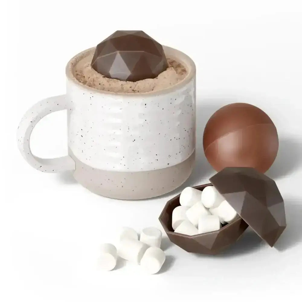 Mug with geometric chocolate bomb and marshmallows on a white background