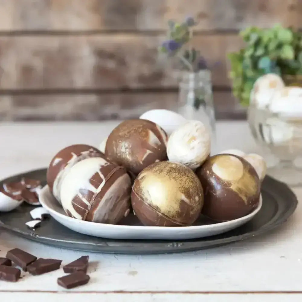 Assorted chocolate-covered treats on a plate with a rustic background