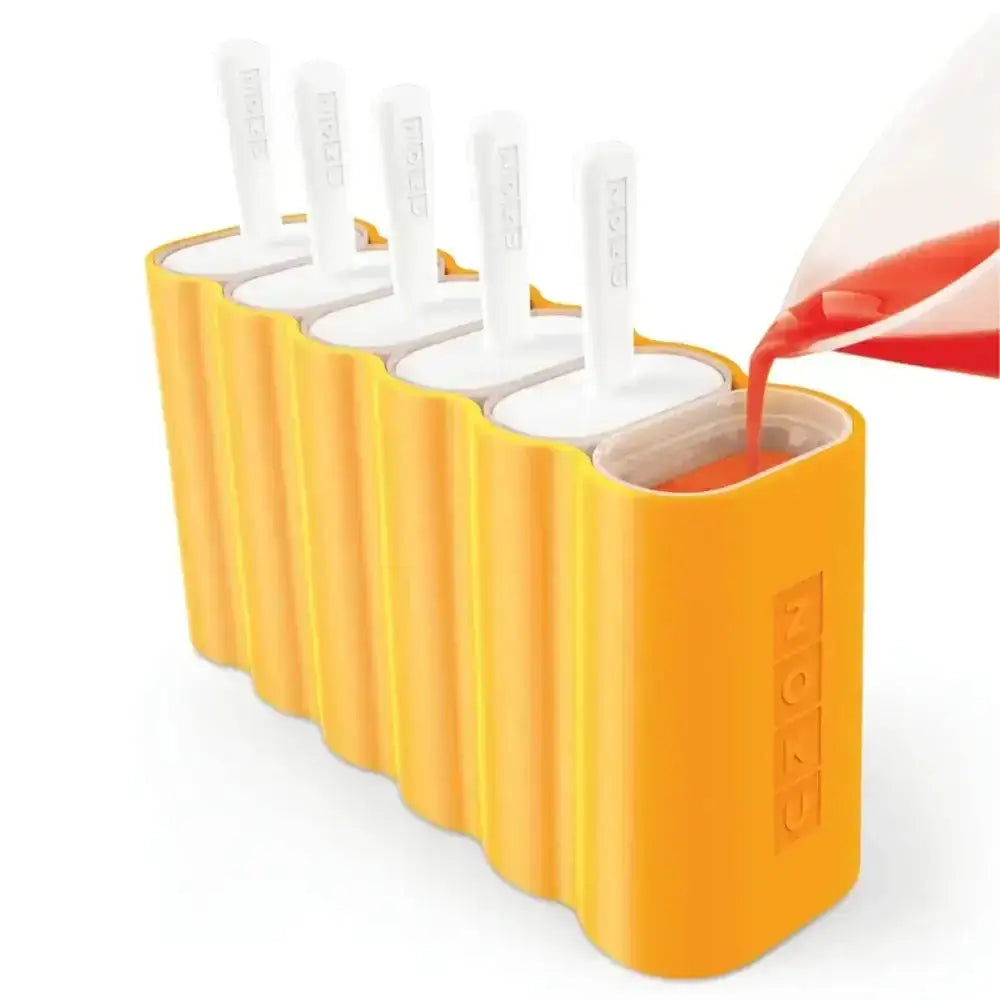 Yellow popsicle mold with white sticks, liquid being poured in for homemade ice pops