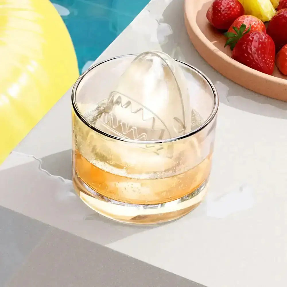 Transparent shark-shaped ice cube made with zoku shark ice ball moulds 2pc in a glass for drinks cooling