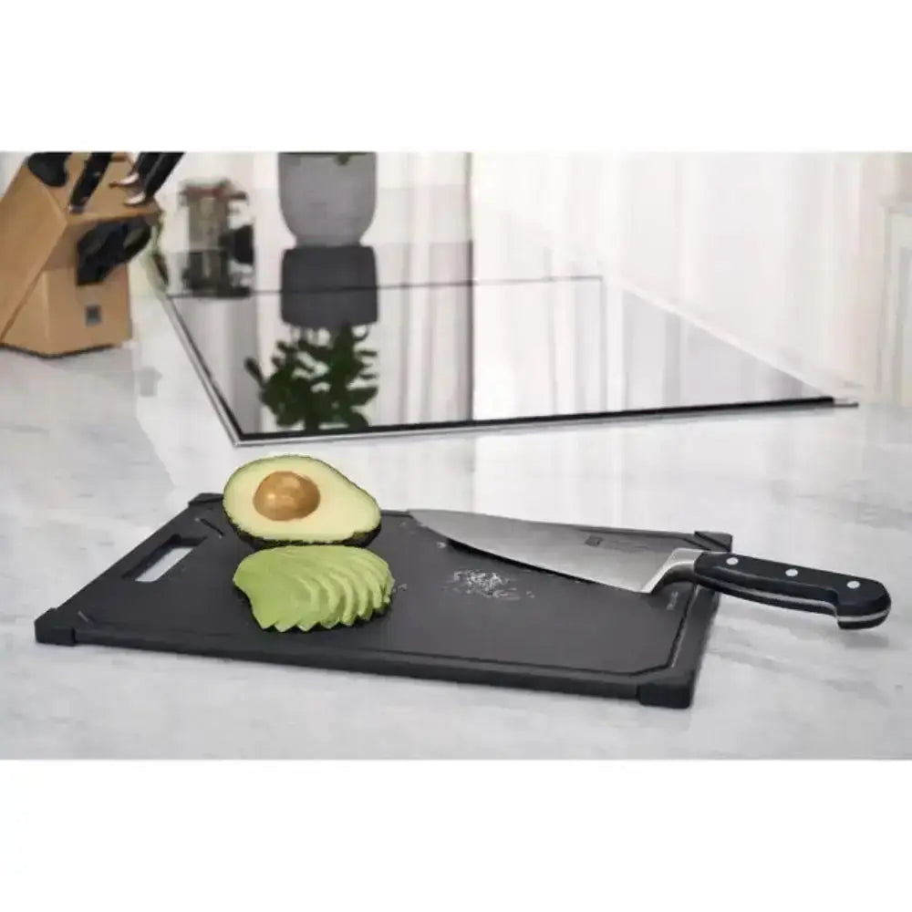 Knife and cutting board with sliced avocado on a kitchen counter