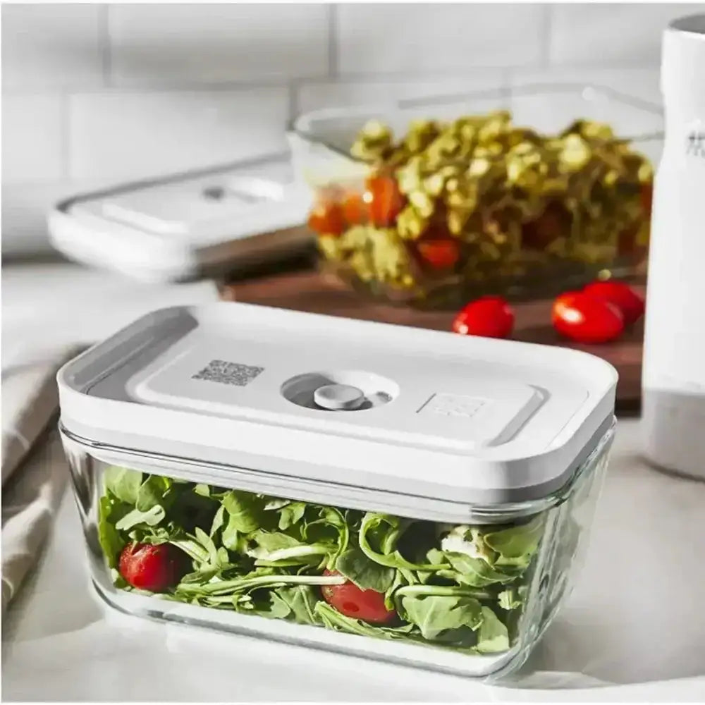 Glass food storage container with salad on a kitchen counter