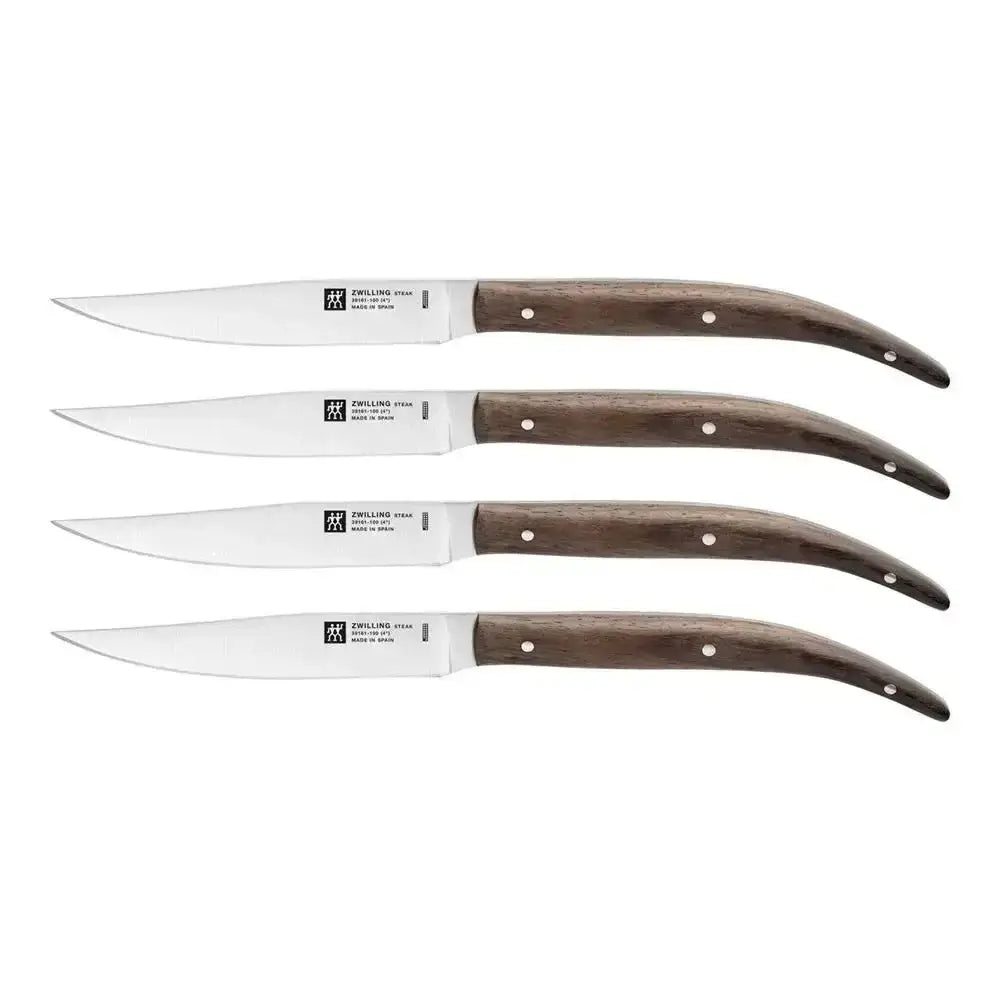 Set of four steak knives with wooden handles on a white background