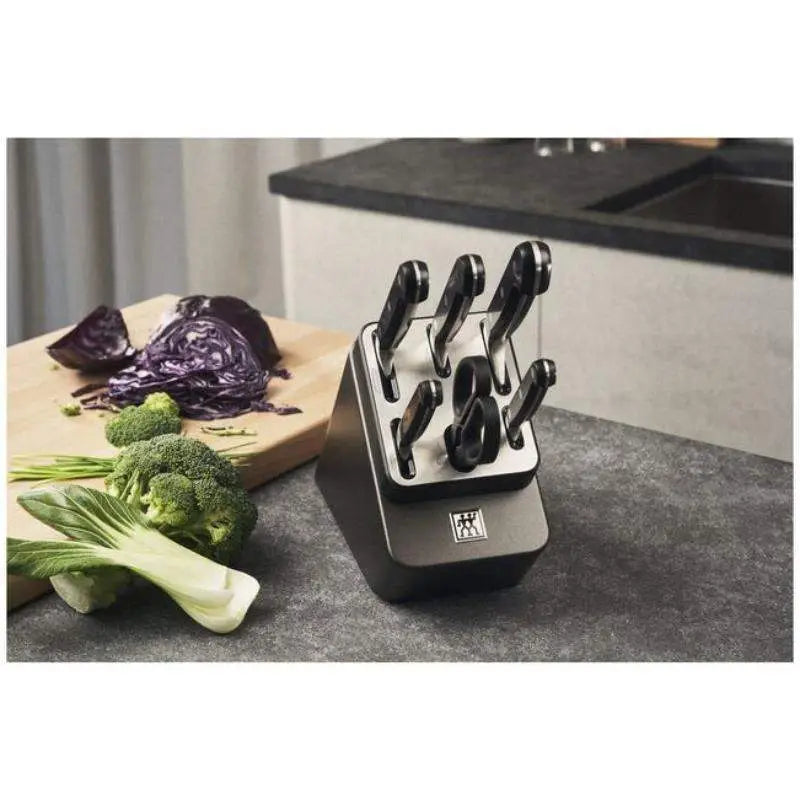 Knife block with knives on a kitchen counter next to vegetables