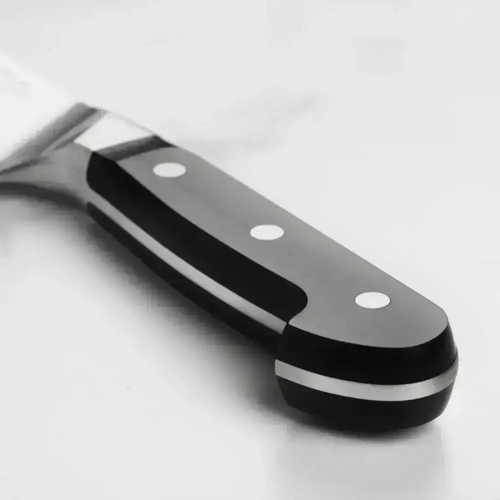 Close-up of a black and silver kitchen knife on a white background