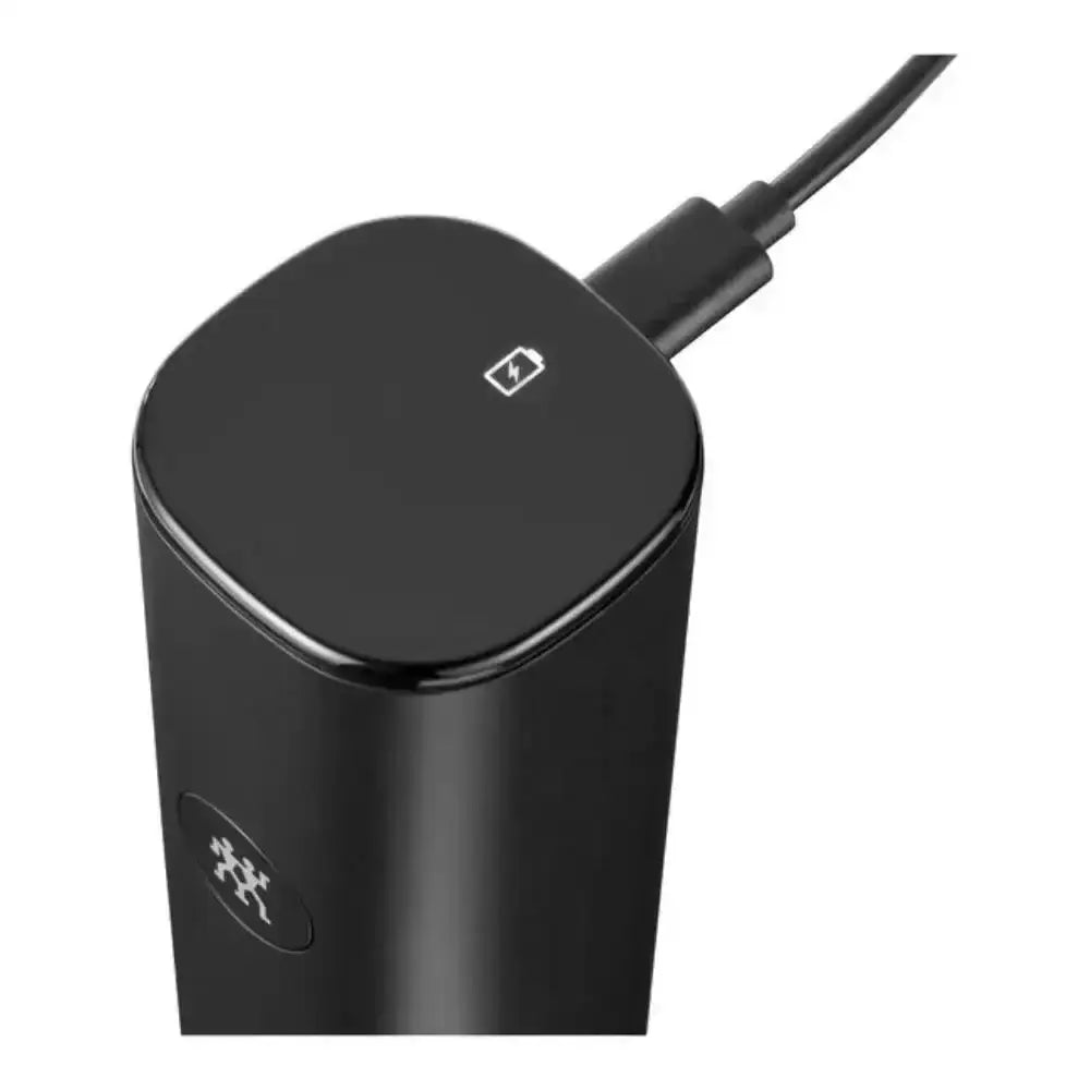 Black cylindrical electronic device with a charging cable on a white background
